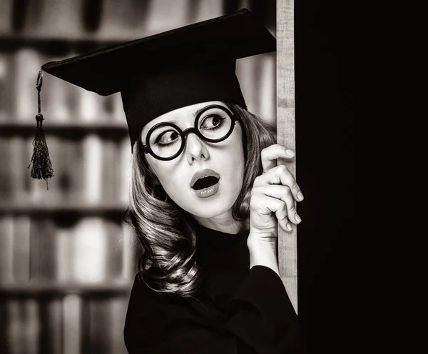 Laurea studentessa in un abito accademico vicino lavagna — Foto Stock