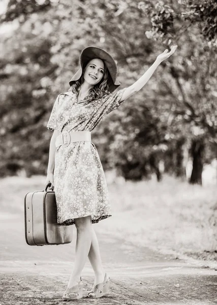 Девушка с чемоданом в переулке деревьев . — стоковое фото