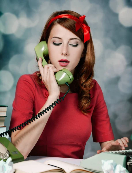 Secretaris in de buurt van de schrijfmachine en dial telefoon — Stockfoto