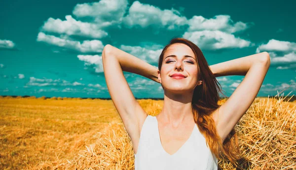 Chica está acostada en el heno y sonriendo — Foto de Stock