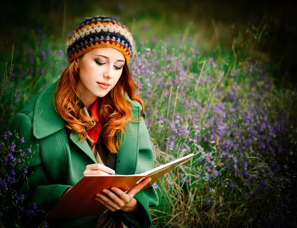 Menina segurando notebook e sentado na grama gren — Fotografia de Stock