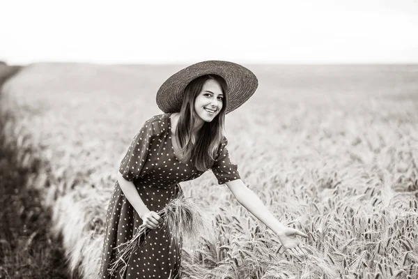 Девушка с фермы держит колосья на поле — стоковое фото