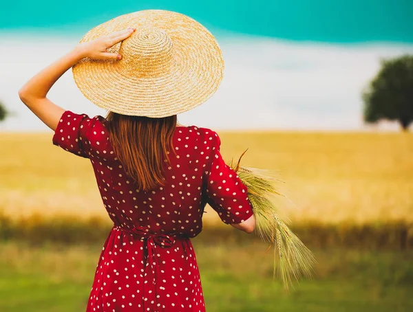 Granjera sosteniendo espigas de trigo en un campo — Foto de Stock