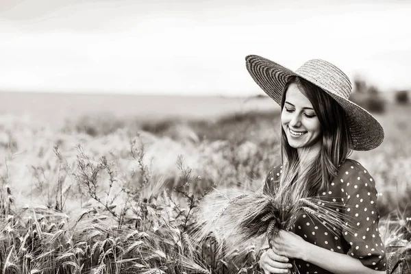 Granjera sosteniendo espigas de trigo en un campo — Foto de Stock