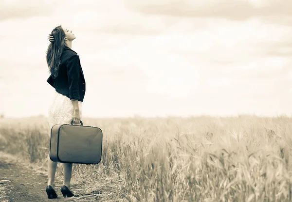 Menina com mala na estrada rural — Fotografia de Stock