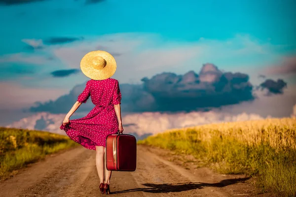 Chica con maleta despertando en camino rural — Foto de Stock