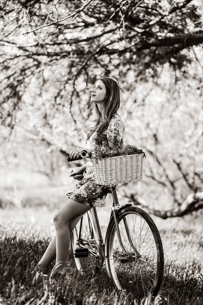 Menina em estilo vestido sentado na bicicleta ao ar livre — Fotografia de Stock