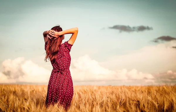 Flickan ser fram på vetefält — Stockfoto