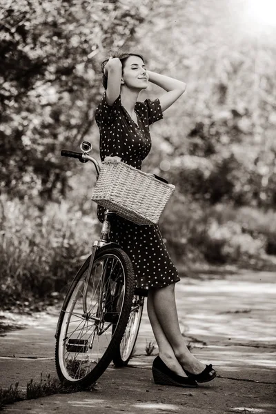 Adult girl with bike at rural road in a park — Stock Photo, Image