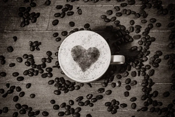 El café y el símbolo de la forma del corazón en ella sobre una mesa — Foto de Stock