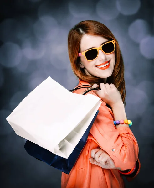 Chica de estilo con bolsas de compras sobre fondo gris —  Fotos de Stock