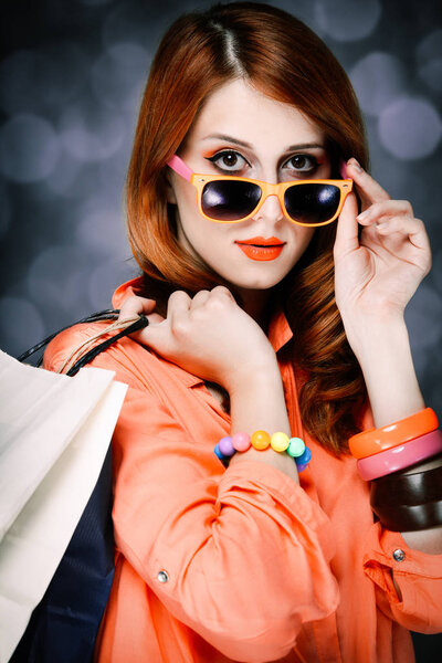 Style girl with shopping bags on gray background