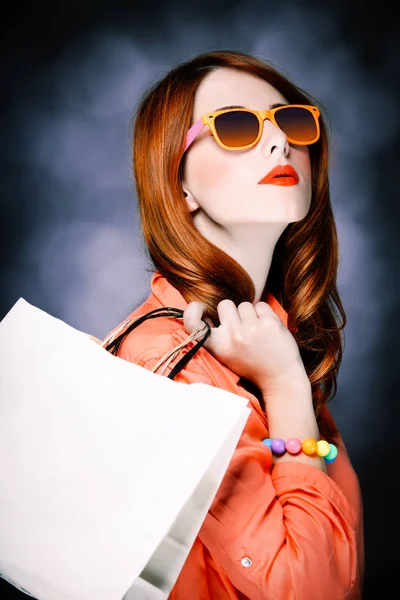 Stil Mädchen mit Einkaufstaschen auf grauem Hintergrund — Stockfoto