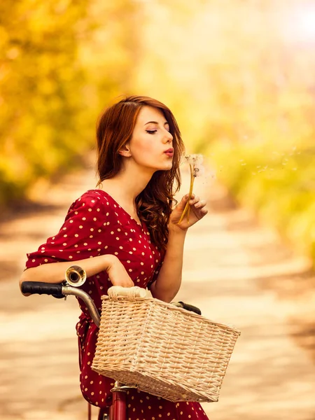 Девушка с велосипедом на сельской дороге в парке — стоковое фото