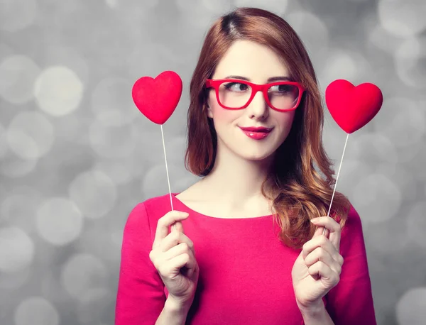 Girl in glasses and dress with two heart shapes — Stock Photo, Image