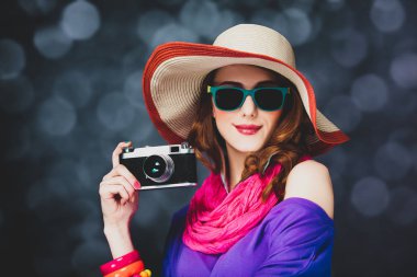Şapka ve güneş gözlüğü ile fotoğraf makinesi şık Kızıl saçlı kız