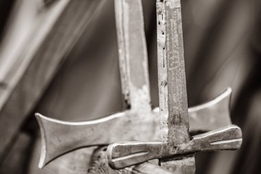 Ahşap masa üzerinde iki metal kılıç.