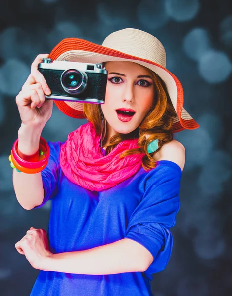 Rossa ragazza in cappello con macchina fotografica e bokeh su sfondo — Foto Stock