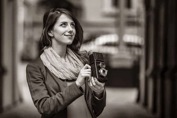 Девушка с винтажной камерой 6x6 на городской улице — стоковое фото