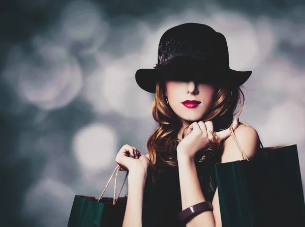 Chica en sombrero negro con bolsas de compras —  Fotos de Stock