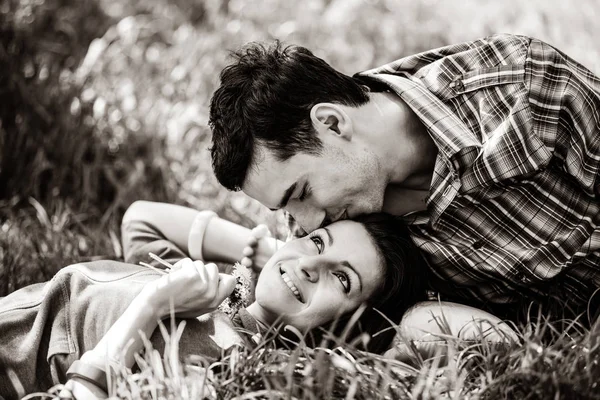 Homem e mulher beijando e deitado na grama — Fotografia de Stock