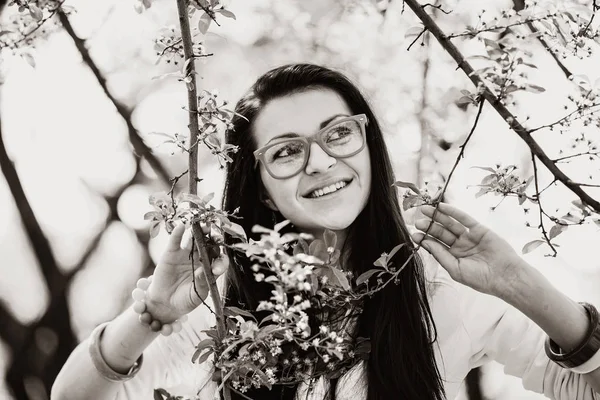 Girl in glasses in spring blooming garden — Stock Photo, Image