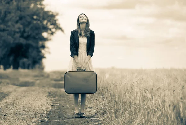 Chica adulta con maleta en camino rural — Foto de Stock