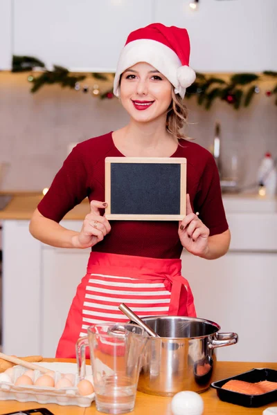 Mädchen hält Tafel beim Kochen — Stockfoto