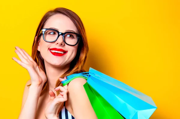 Mulher em óculos pretos com sacos de compras a cores — Fotografia de Stock