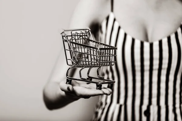 Woman holding metal shopping cart in hand — Stock Photo, Image