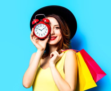 Çalar saat ve alışveriş torbaları kadın ile