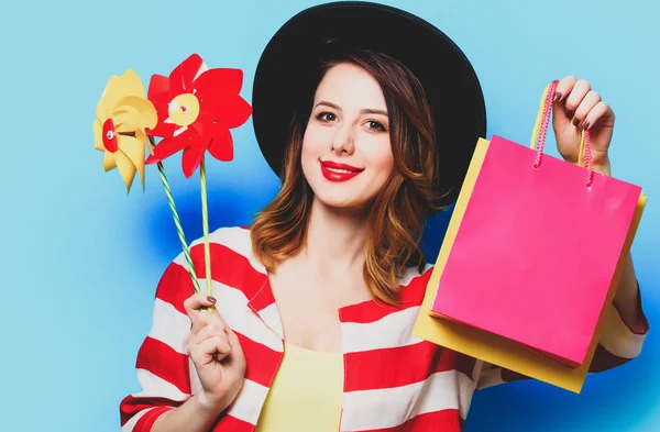 Vrouw met pinwheels en boodschappentassen — Stockfoto