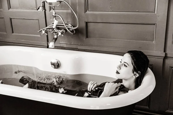 Молода жінка в ванні з квітами — стокове фото