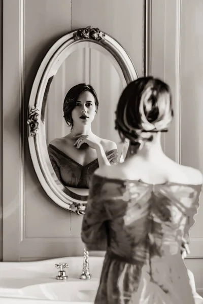 Jovem mulher olhando para o espelho — Fotografia de Stock
