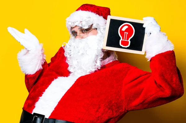 Funny Santa Claus sosteniendo tablero negro — Foto de Stock