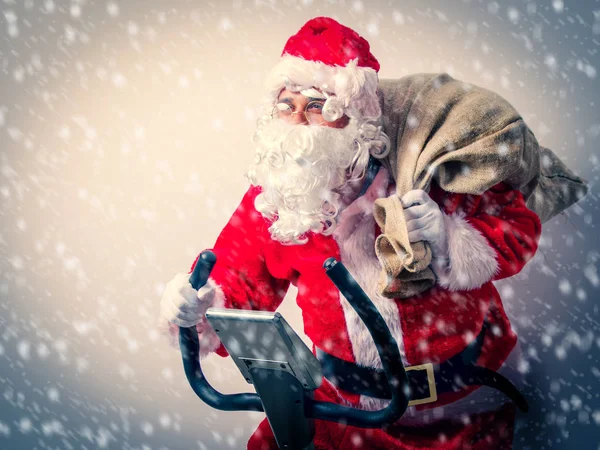 Papai Noel se divertir com bicicletas de exercício — Fotografia de Stock