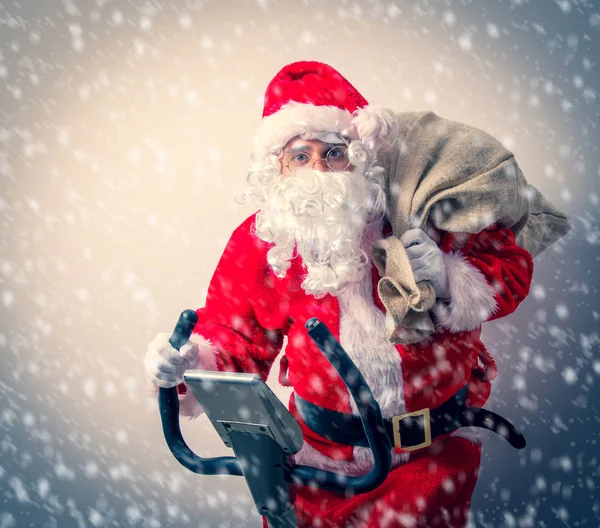 Papai Noel se divertir com bicicletas de exercício — Fotografia de Stock