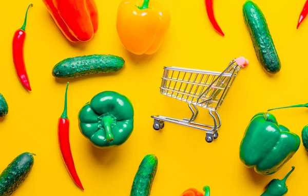 Chilipeper en komkommers met winkelwagen — Stockfoto