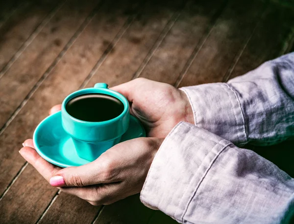 Manos de mujer sosteniendo pequeña taza azul de café — Foto de Stock