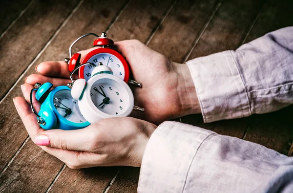 Young woman hands holding alarm clocks — Stock Photo, Image