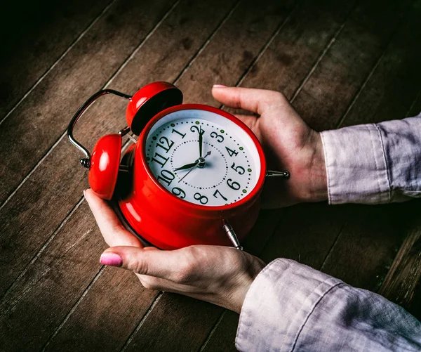 Joven mujer manos sosteniendo reloj despertador rojo —  Fotos de Stock