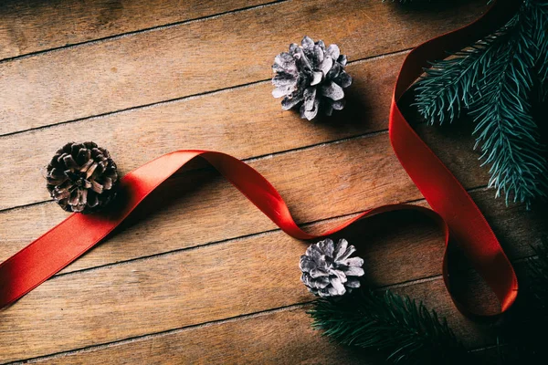 Red twisted Christmas bow and pine cones — Stock Photo, Image