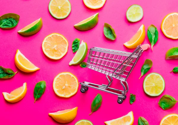 Gesneden citroenen en limoenen en winkelwagen — Stockfoto