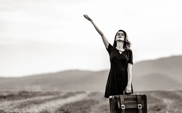 Woman at countryside with suitcase — Stock Photo, Image