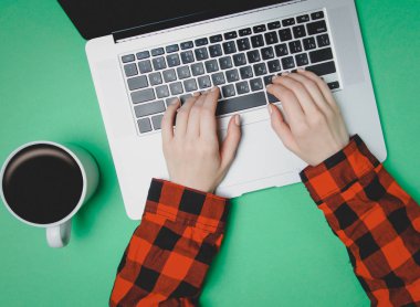 Fincan kahve ve dizüstü bilgisayar ile serbest meslek sahibi kadın el