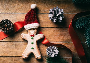 Yükseklik ginbgerbread adam kurabiye ve Noel Baba şapkasını ahşap arka plan üzerinde görüş açısı