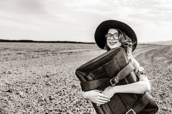 Kvinna på landsbygden med resväska — Stockfoto