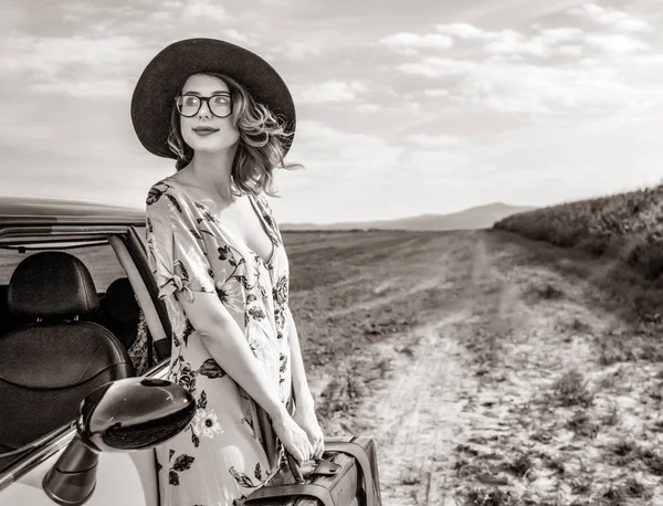 Vrouw met kaart en koffer in de buurt van een auto — Stockfoto