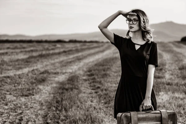Mujer en el campo con maleta — Foto de Stock