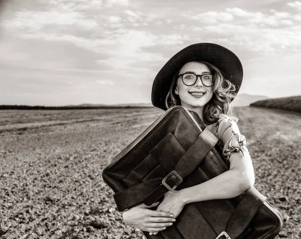 Vrouw op platteland met koffer — Stockfoto